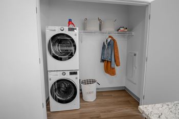 A small laundry room with a washer and dryer stacked on top of each other.